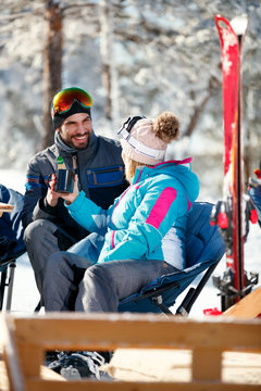 Couple spending time together and drink after skiing in cafe at ski resort