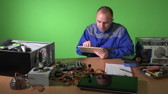 Carefree technician man using tablet talk with customer. broken computer parts