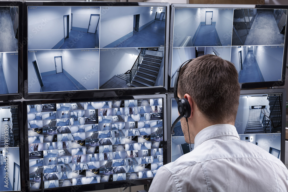 Poster Operator Looking At Multiple Camera Footage On Computer