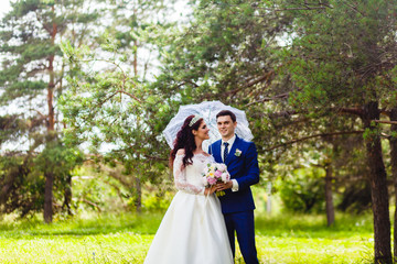 Obraz na płótnie Canvas Beautiful couple newlyweds with the white umbrella