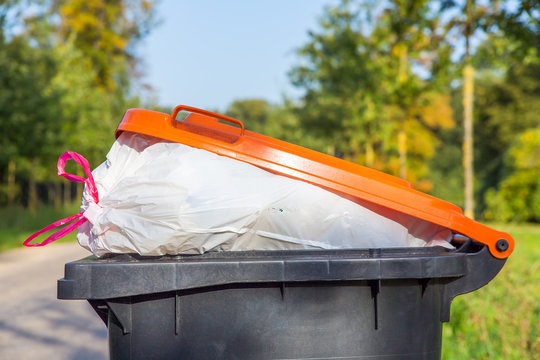 Filled garbage can standing in nature