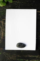 white paper sheet on a black wooden table, mock up