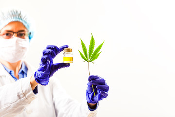 Woman doctor holding a cannabis leaf and oil