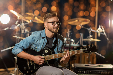 musician playing guitar at studio over lights