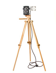 Old Soviet camera on a wooden tripod with a lamp isolated on a white background