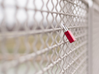 A red love padlock locked to a bridge