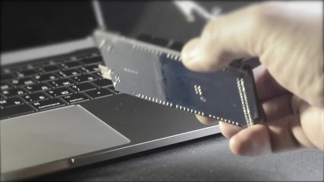 A man's hand takes a DIY board against a laptop background. Robototechnic, DIY, electronic. Mega board.