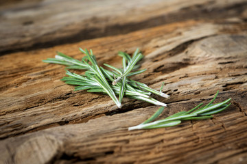 sprigs of rosemary on wooden background