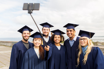 group of happy students or graduates taking selfie