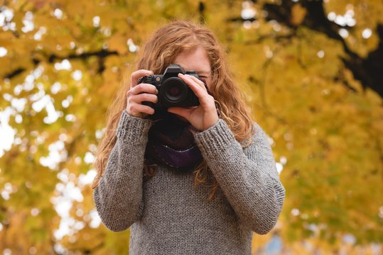 Woman taking a photo with digital camera outdoors