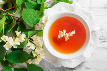 Cup of green tea with jasmine flowers