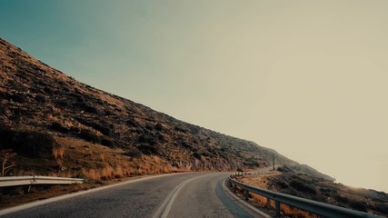 Coast to coast pov driving an a sunny winter morning.Driving point of view on the asphalt coastal road on a dramatic bright winter day at sunrise