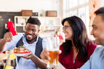 happy friends eating at restaurant
