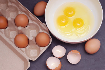 Whipping Chicken Eggs. Yolks and Egg protein in a Cup. Preparation of Food and Chicken Eggs. Eggshell on a cutting board. Top View. Dark Blue Background.