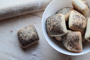 Lush homemade buns with poppy seeds on the wooden background.