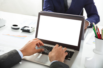 Close-up Of Two Businesspeople Working On Laptop