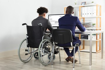 Physically Impaired Businessman With His Partner Working