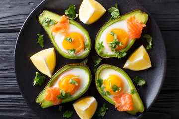 Organic baked avocado stuffed with egg and salmon closeup. horizontal top view