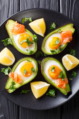 Organic baked avocado stuffed with egg and salmon closeup. Vertical top view