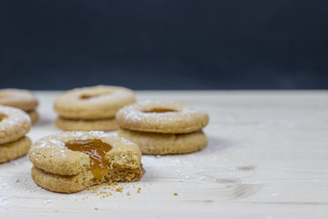 Delicate shortbread cookie with apricot marmalade on a wooden table  Minimal baking concept. 