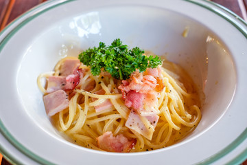 Spaghetti Carbonara with bacon, ham and vegetable in bowl