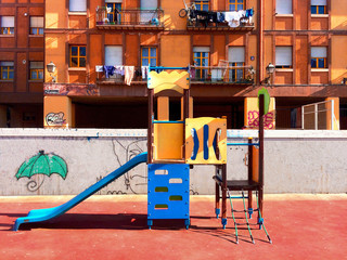 An orange building and an empty playground in Madrid, Spain.