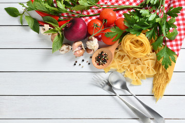 Pasta spaghetti, farfalle, linguine with vegetables and spices on white wooden table