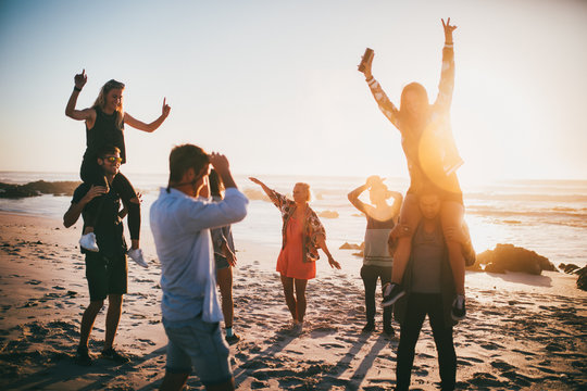 Group Of Happy Friends Dancing At Beach Party