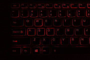 Red backlit computer keyboard macro shot of enter key - obrazy, fototapety, plakaty
