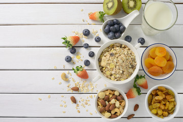 Healthy food, healthy muesli breakfast with milk and fruits on white wooden table