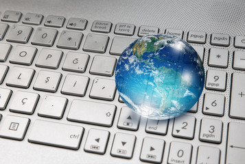 Glass globe on laptop keyboard 