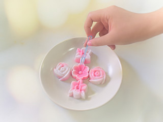 hand hold fork stab pink jelly mould flower shap on dish