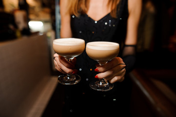 girl holding two glasses with an alcoholic cocktail sour mix
