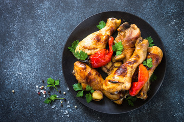 Grilled Chicken drumsticks on black bakground.