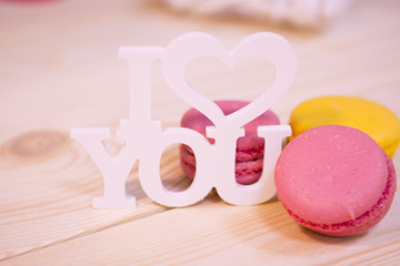 Concept of St.Valentine's Day, Love, Anniversary, Wedding with I love you inscription and macaroons in a close up, light blurred background