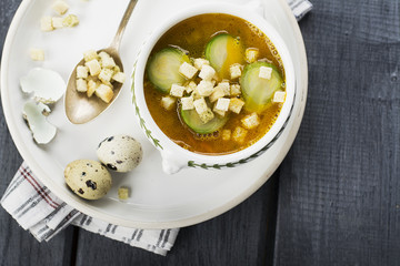 Homemade soup with brussels sprouts and croutons in white bowl decorated with a sprig of thyme. selective Focus