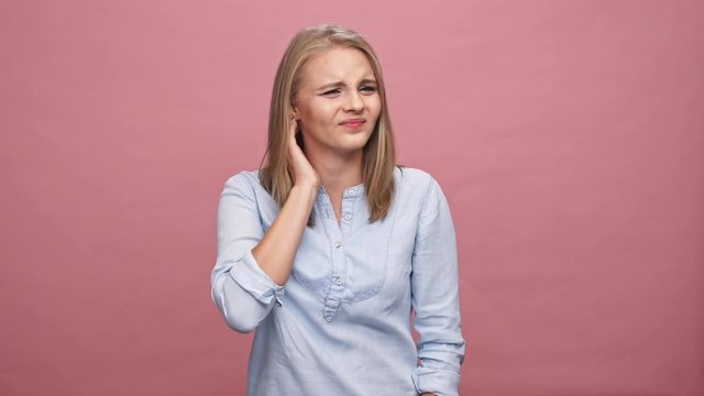 Confused blonde woman in shirt having scabies over pink background