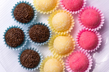 Brigadeiro Beijinho and Bicho de Pe: sweets from Brazil. Child birthday party. Flat lay design of candy ball. Macro, close up.