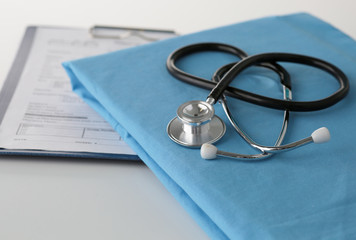 Stethoscope on a table with medical uniform