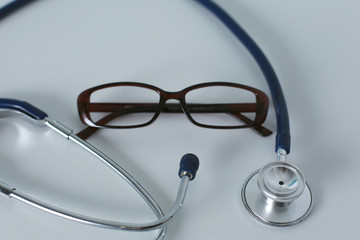 medical stethoscope and glasses lie on the table