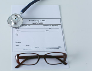 medical stethoscope and glasses lie on the table