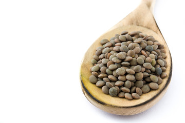 Lentils grain on wooden spoon isolated on white background.Copyspace