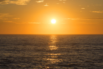 Golden sunset centered over empty ocean