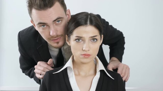 Harassment. Young boss in a suit whispers in the ear of his secretary. The girl is angry and in perplexity 60 fps