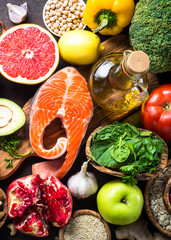 Balanced diet food background. Fish, leguminous, vegetables, fruit, seed and nuts. Top view.