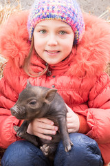 Adorable little childs in colorful clothers playing with just born piglets in winter fermers yard. Creative leisure with kids on swine farm