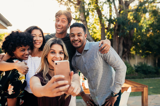 Group of friends at housewarming party taking selfie