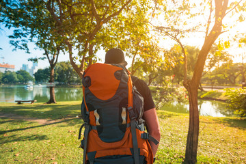 Man with backpack walking in a park in daylight