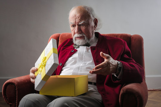 Elderly man opening a present