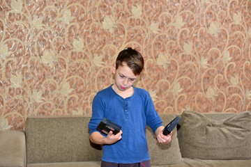 The boy is surprised to see the old vidiocasset. Choice: video cassette or audio. A surprised boy...